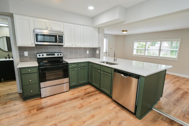 189 N Gould Rd, Bexley, OH 43209 - kitchen with green cabinetry, stainless steel appliances, a sink, a peninsula, and recessed lighting