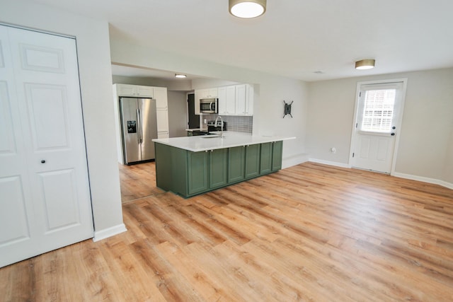 189 N Gould Rd, Bexley, OH 43209 - kitchen with stainless steel appliances, green cabinets, a peninsula, and light wood finished floors