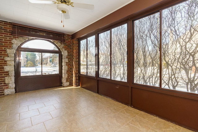 unfurnished sunroom with ceiling fan