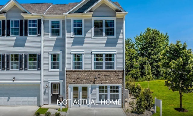 townhome / multi-family property featuring a garage and a front lawn