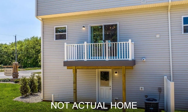 rear view of house with central air condition unit and a balcony