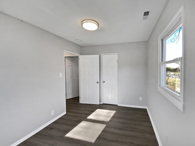 unfurnished bedroom with dark wood-type flooring