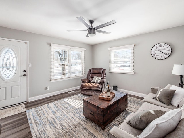 living room featuring ceiling fan and dark wood-type flooring