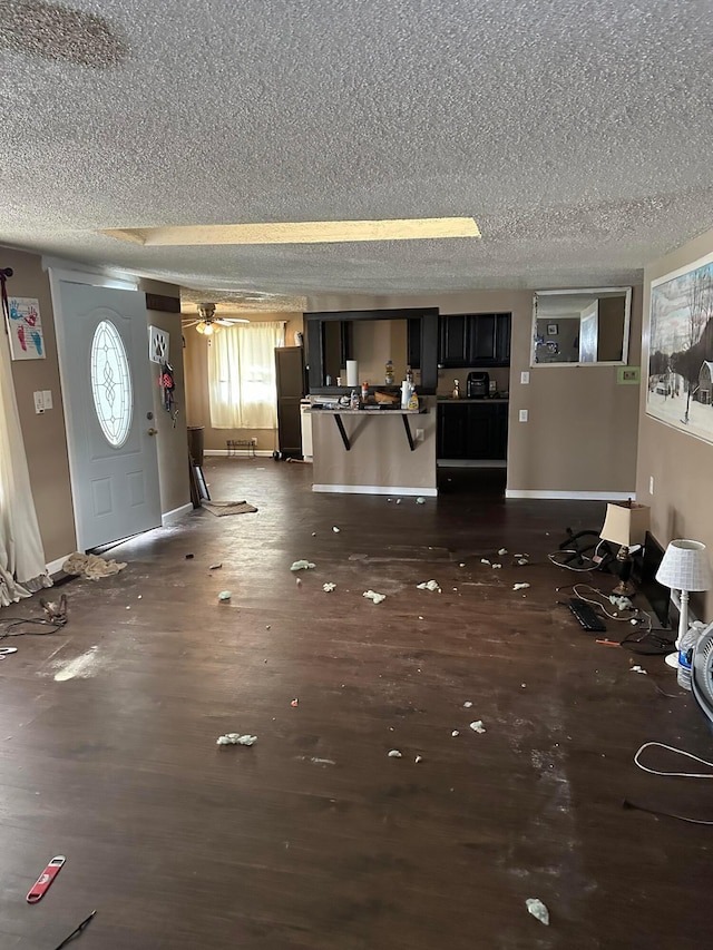 interior space with ceiling fan, dark hardwood / wood-style flooring, and a textured ceiling