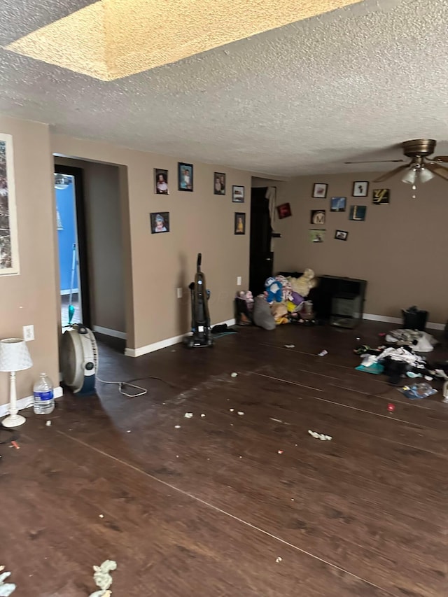 unfurnished living room featuring ceiling fan and a textured ceiling