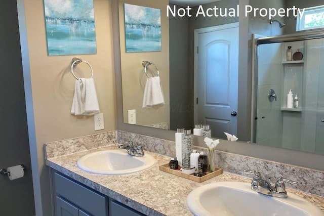 bathroom featuring a sink, a shower stall, and double vanity