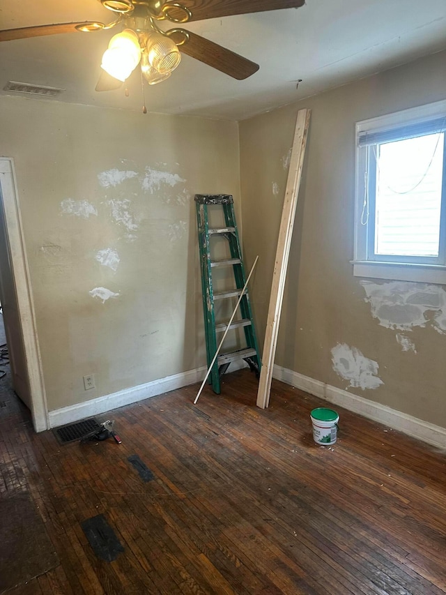 spare room with visible vents, a ceiling fan, hardwood / wood-style flooring, and baseboards