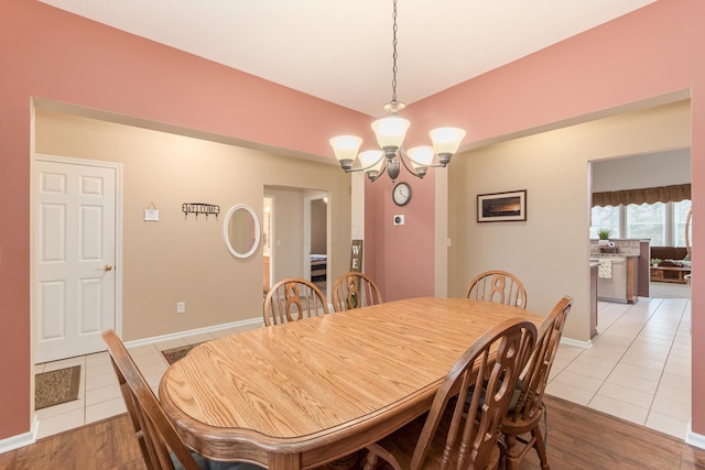 dining room with tile patterned floors, baseboards, and an inviting chandelier