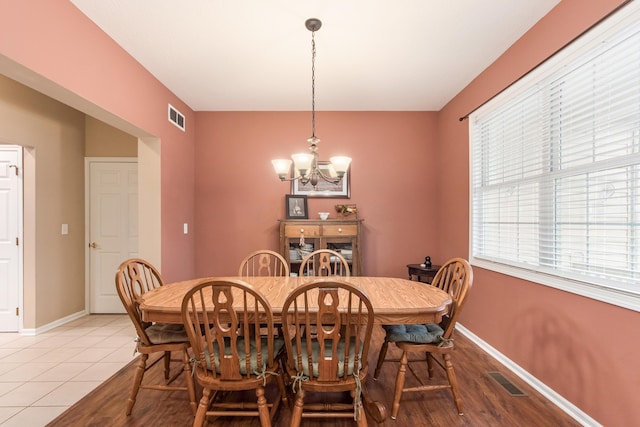 dining space featuring baseboards, visible vents, and a chandelier