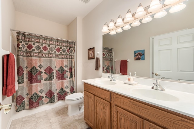 full bath with toilet, double vanity, visible vents, and a sink