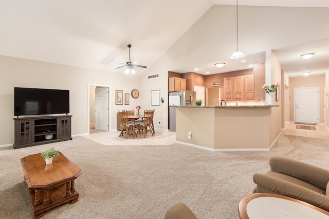 living room with ceiling fan, high vaulted ceiling, light colored carpet, visible vents, and baseboards