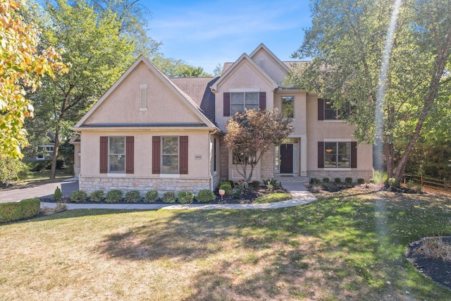 view of front of property with stone siding, a front lawn, and stucco siding