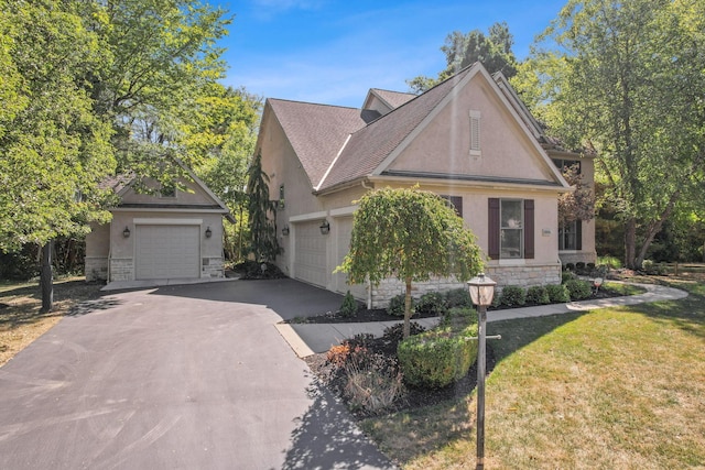 view of front of house featuring stone siding, a front lawn, a shingled roof, and stucco siding