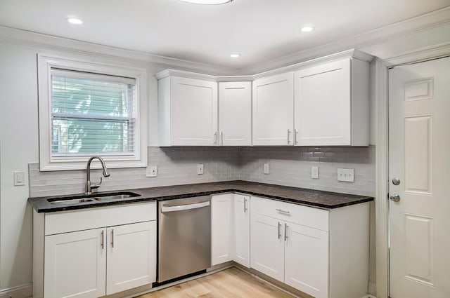 kitchen featuring dishwasher, dark stone counters, white cabinets, backsplash, and sink