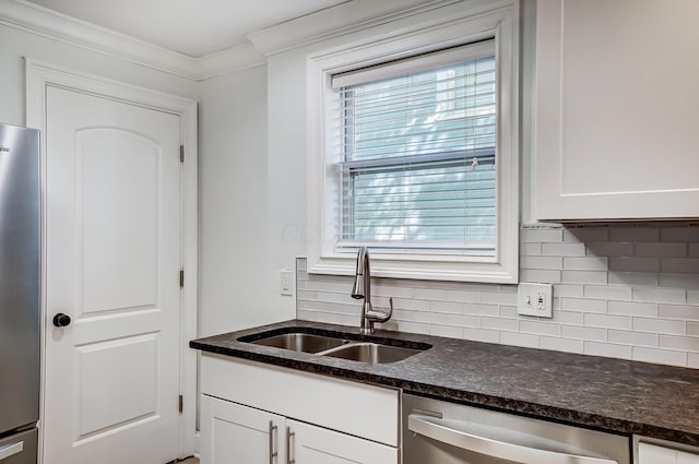 kitchen featuring sink, backsplash, appliances with stainless steel finishes, white cabinets, and crown molding