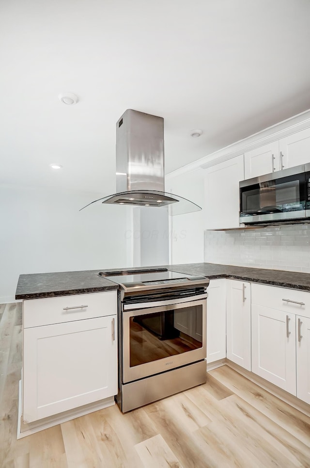 kitchen featuring appliances with stainless steel finishes, white cabinets, island exhaust hood, and light hardwood / wood-style flooring