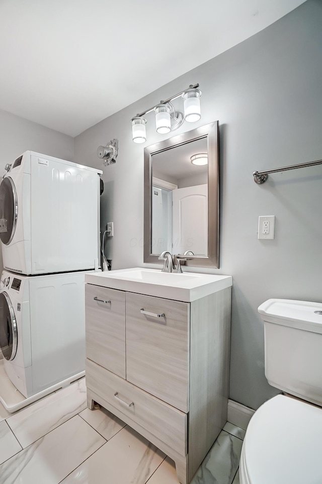 bathroom with toilet, stacked washer / drying machine, and vanity