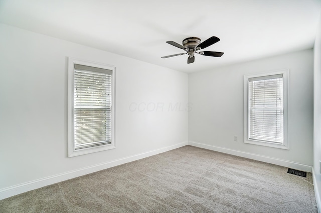 carpeted spare room with ceiling fan