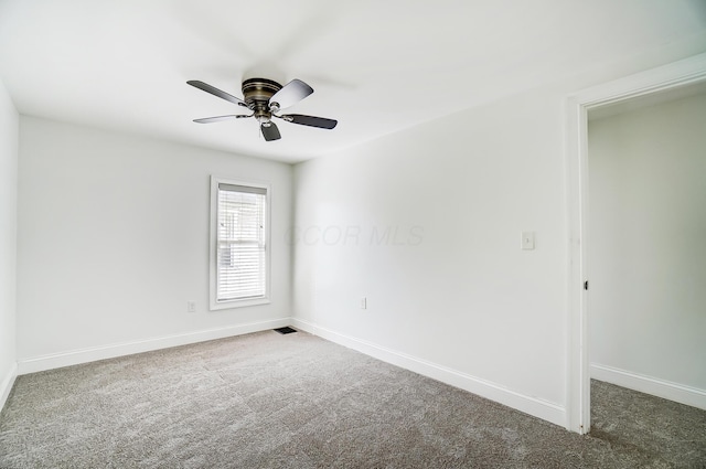 unfurnished room with dark colored carpet and ceiling fan