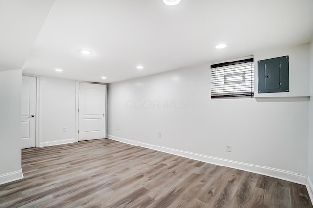 basement with electric panel and wood-type flooring