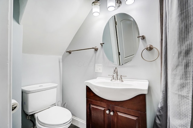 bathroom with toilet, lofted ceiling, and vanity