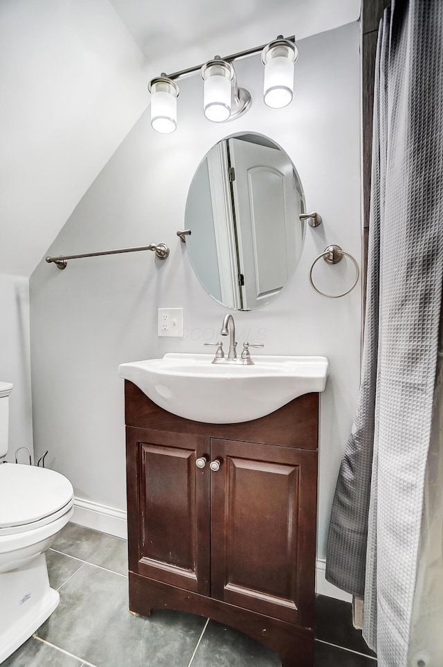 bathroom featuring toilet, vanity, tile patterned flooring, and vaulted ceiling