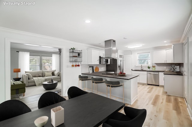 kitchen with white cabinetry, crown molding, and stainless steel appliances