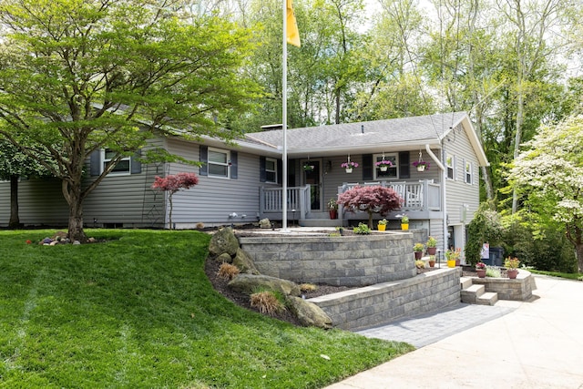 ranch-style home featuring covered porch and a front lawn