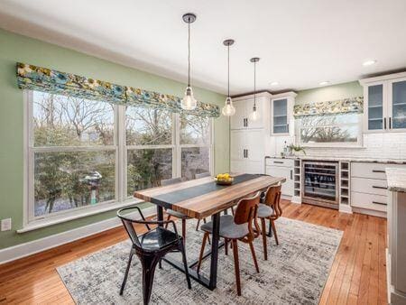 dining area featuring beverage cooler, light wood finished floors, recessed lighting, and baseboards