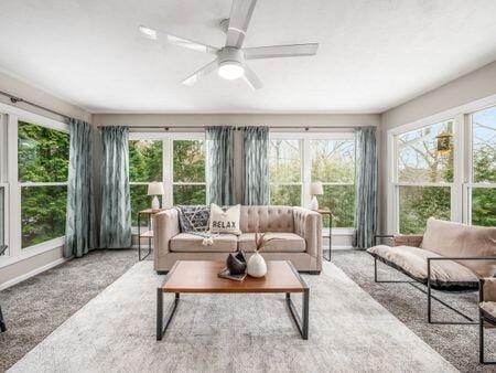 sunroom / solarium featuring a healthy amount of sunlight and a ceiling fan