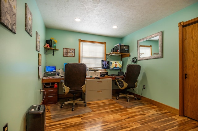 office featuring a textured ceiling, baseboards, wood finished floors, and recessed lighting