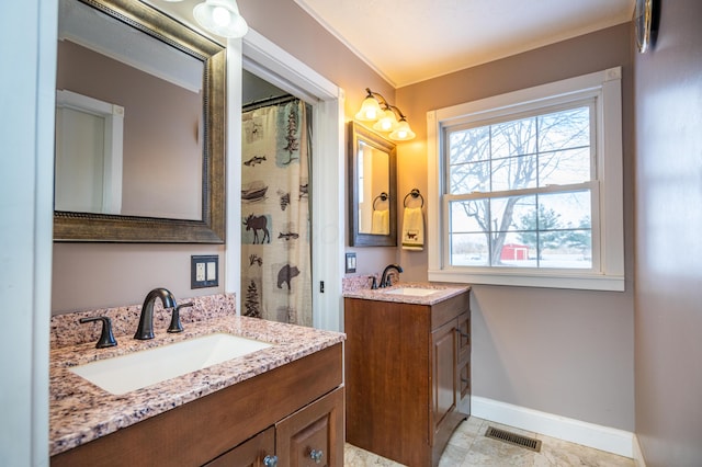 bathroom featuring baseboards, visible vents, two vanities, and a sink