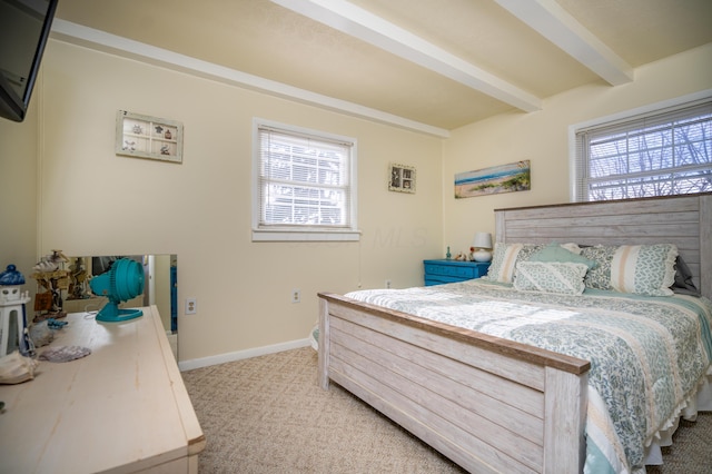 bedroom featuring light carpet, baseboards, and beamed ceiling