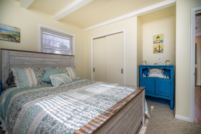 bedroom featuring light carpet, baseboards, a closet, and beamed ceiling