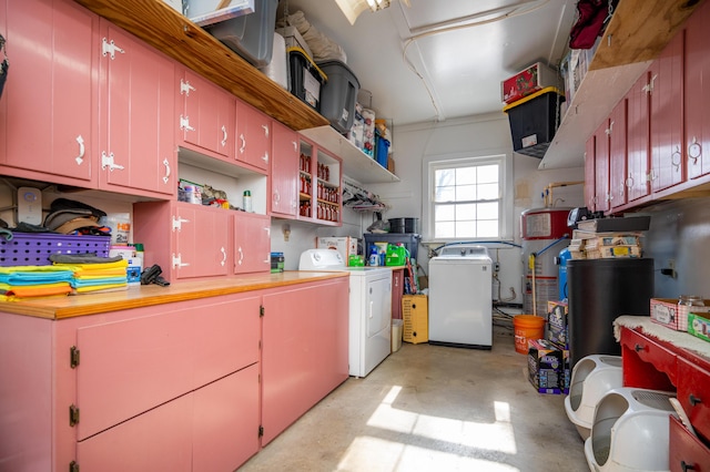 kitchen featuring open shelves, concrete floors, red cabinetry, and washing machine and clothes dryer