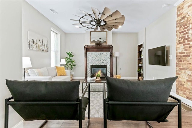 living room featuring a tile fireplace and light hardwood / wood-style floors