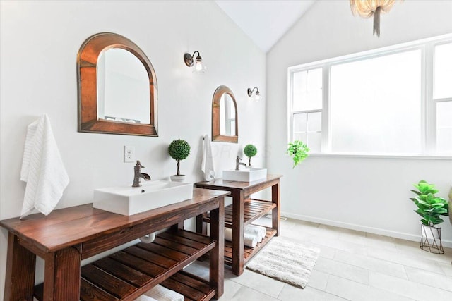 bathroom featuring tile patterned floors, lofted ceiling, and sink