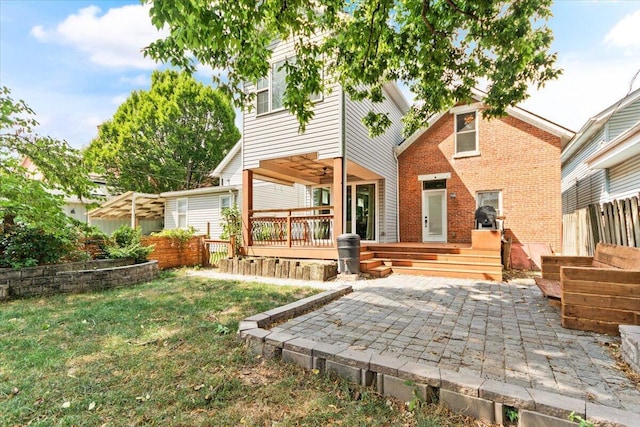 back of house featuring a lawn and a patio area