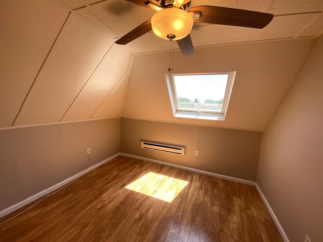 additional living space with ceiling fan, vaulted ceiling, dark wood-type flooring, and a wall mounted AC