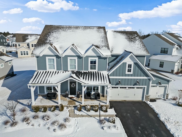 view of front of property with a garage, driveway, board and batten siding, and a residential view