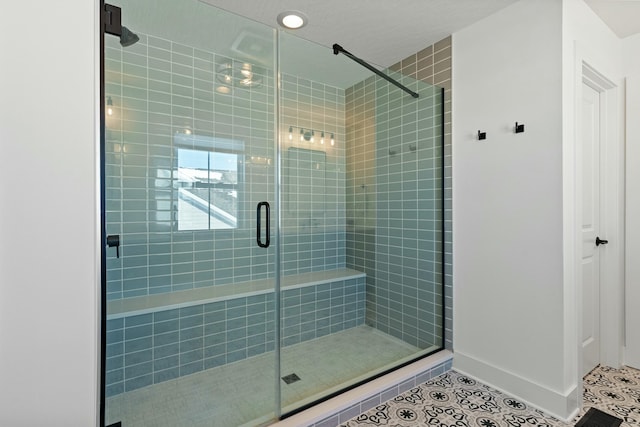 full bathroom featuring tile patterned flooring, baseboards, and a shower stall