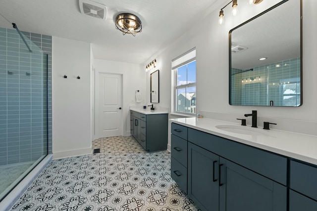 full bathroom featuring a stall shower, visible vents, two vanities, and a sink