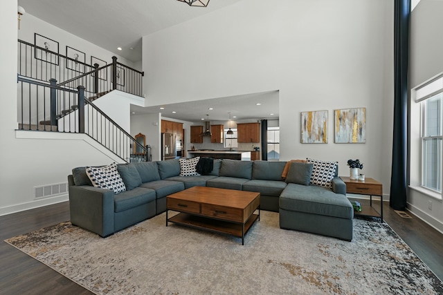 living area featuring stairs, plenty of natural light, wood finished floors, and visible vents