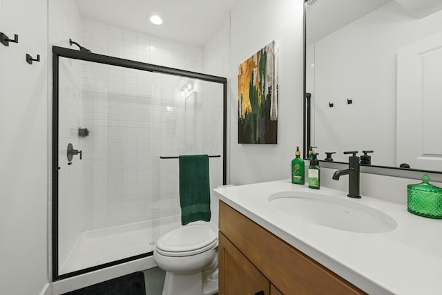 full bathroom featuring a shower stall, vanity, and toilet