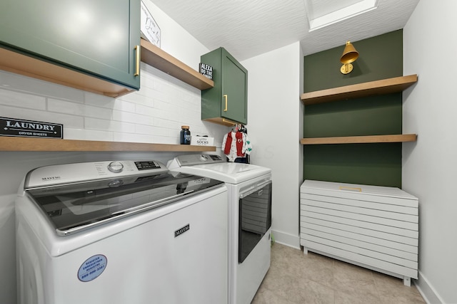 laundry room featuring baseboards, cabinet space, and washing machine and clothes dryer