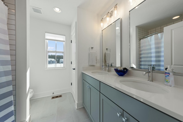 full bathroom with double vanity, a sink, and visible vents