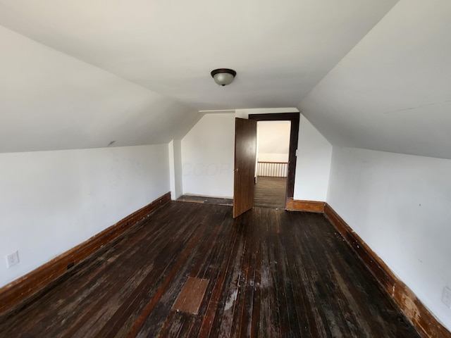 additional living space featuring vaulted ceiling and dark hardwood / wood-style flooring