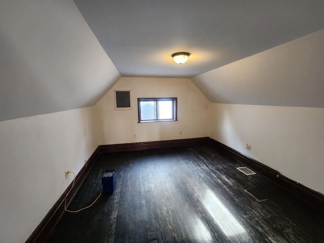 bonus room featuring electric panel, dark hardwood / wood-style floors, and lofted ceiling