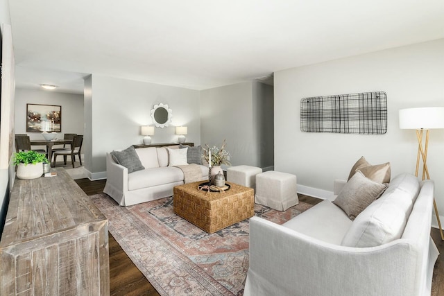 living area with baseboards and wood finished floors