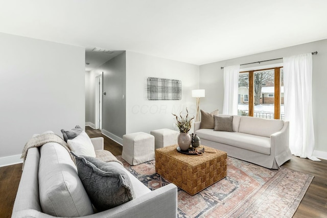 living area featuring visible vents, baseboards, and wood finished floors